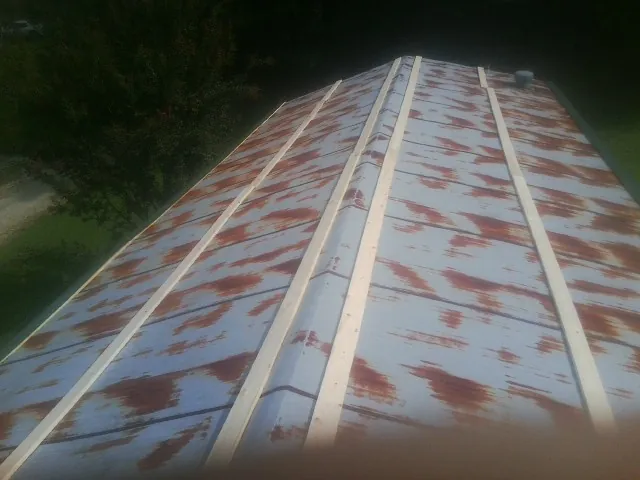 Rusted metal roof panels with new wood purlins before replacement — Storm Damage Roof Repair in Kirkman by Roofing Brothers