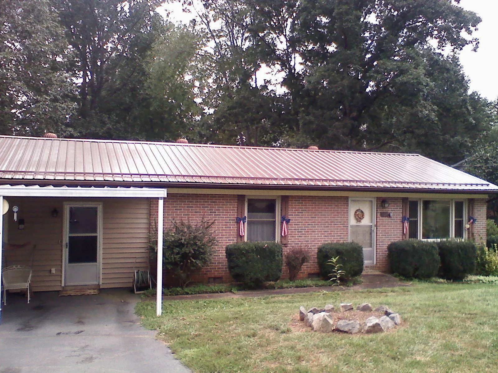 Bronze metal roof and carport on a brick ranch home — Roof Repair work by our crew in Kirkman